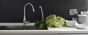 Lettuce on a counter next to a sink